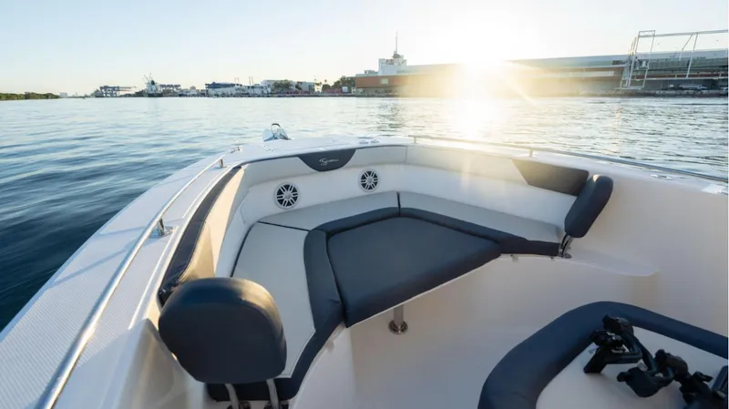 Slide: The Image of 2024 SeaWell 240CC boat interior with seating, on calm water at sunset. - 27