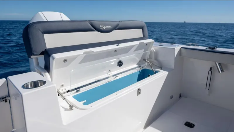 Slide: The Image of 2024 SeaWell 240CC boat with open storage compartment, ocean backdrop. - 44