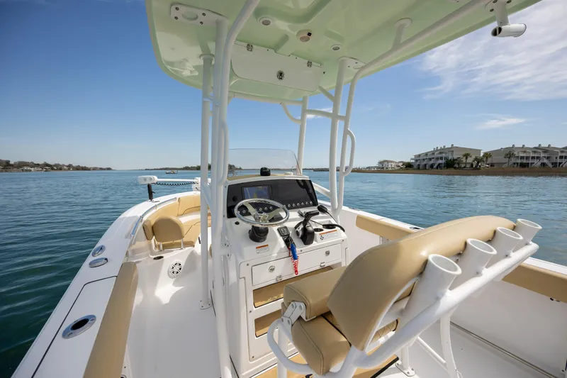 Slide: The Image of 2021 Sportsman Heritage 231 Center Console boat on calm water, featuring beige seating and modern controls. - 11