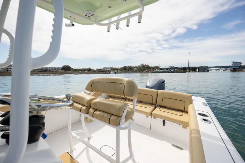 Slide: The Image of 2021 Sportsman Heritage 231 Center Console boat on calm water, featuring beige seating. - 14