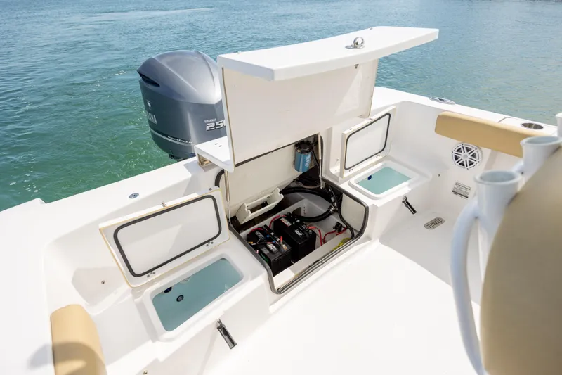 Slide: The Image of 2021 Sportsman Heritage 231 Center Console boat with open storage compartments and visible engine. - 30