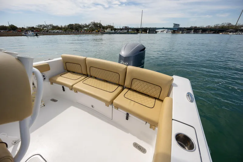 Slide: The Image of 2021 Sportsman Heritage 231 Center Console boat with tan seating, docked on calm water. - 31