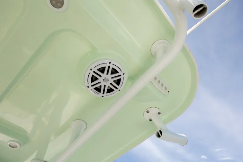 Slide: The Image of 2021 Sportsman Heritage 231 Center Console boat speaker and rod holders under blue sky. - 8