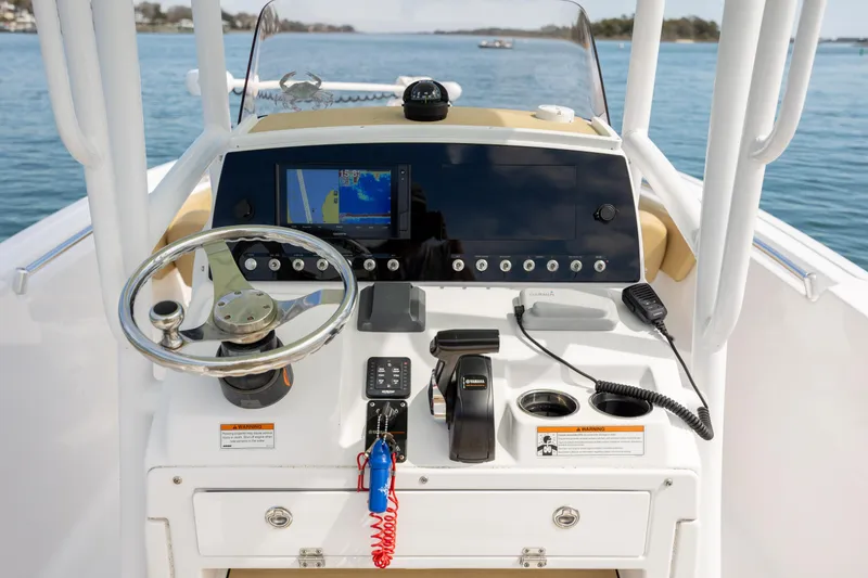 Slide: The Image of 2021 Sportsman Heritage 231 Center Console boat dashboard with steering wheel and navigation equipment. - 9