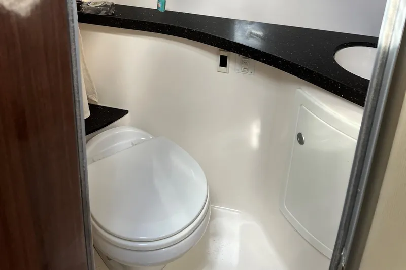 Slide: The Image of 2014 Regal 28 Express boat bathroom with modern fixtures and black countertop. - 13