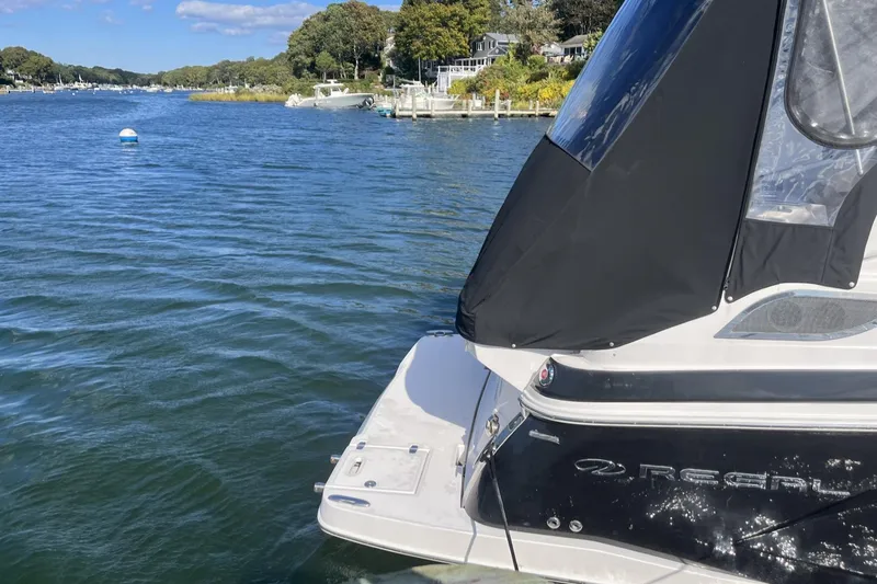 Slide: The Image of 2014 Regal 28 Express boat docked on a scenic lake. - 2