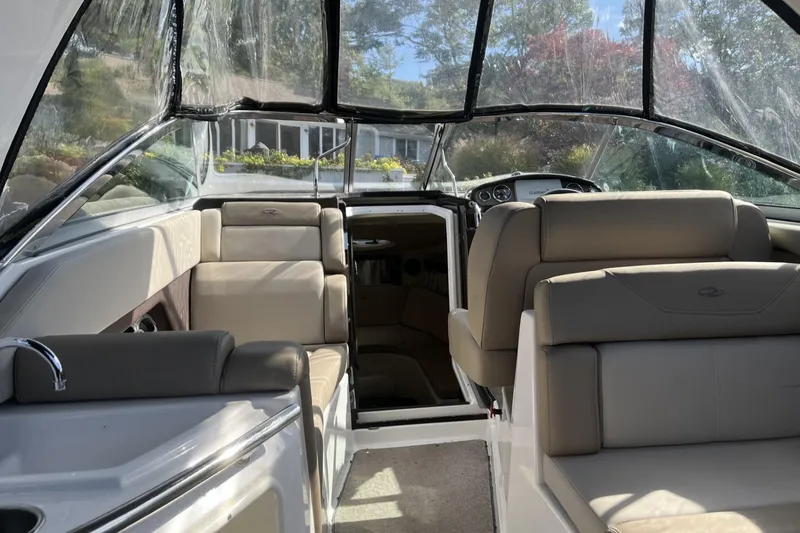 Slide: The Image of Interior of a 2014 Regal 28 Express boat with beige seating and clear canopy. - 3