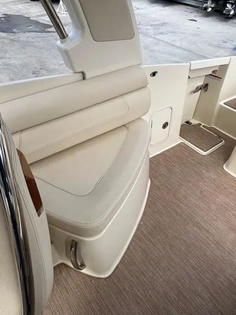 Slide: The Image of 2022 Chris-Craft Launch 28 GT interior with beige seating and carpeted flooring. - 13