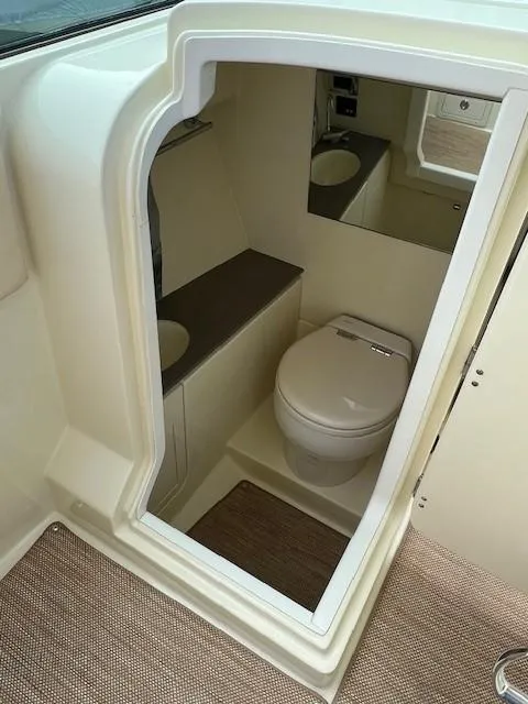 Slide: The Image of 2022 Chris-Craft Launch 28 GT boat interior with compact bathroom and toilet. - 15