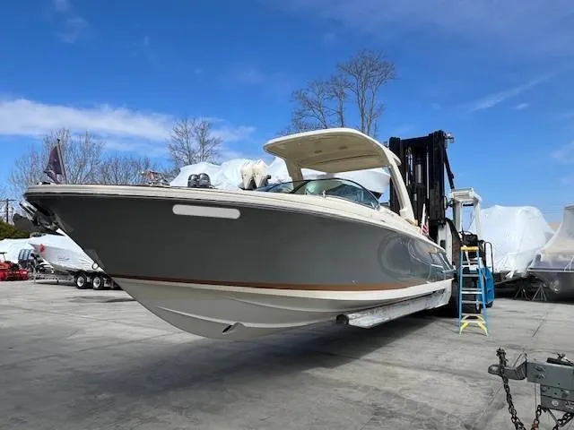 Slide: The Image of 2022 Chris-Craft Launch 28 GT boat on a lift, under clear blue sky. - 5