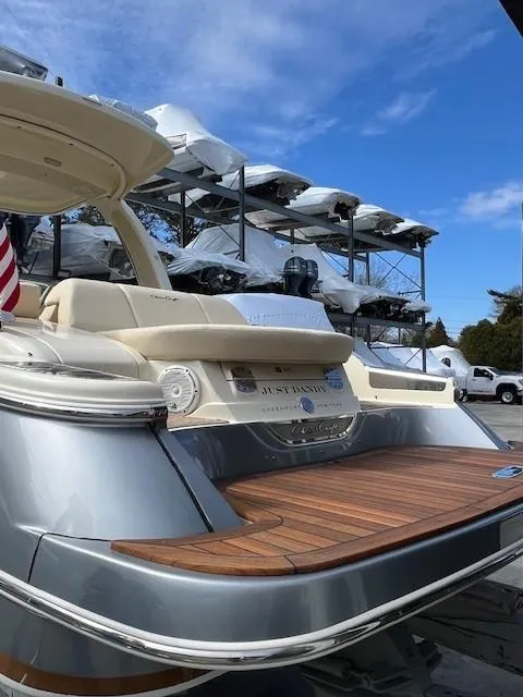 Slide: The Image of 2022 Chris-Craft Launch 28 GT boat with elegant design and wooden deck, docked under a clear sky. - 7