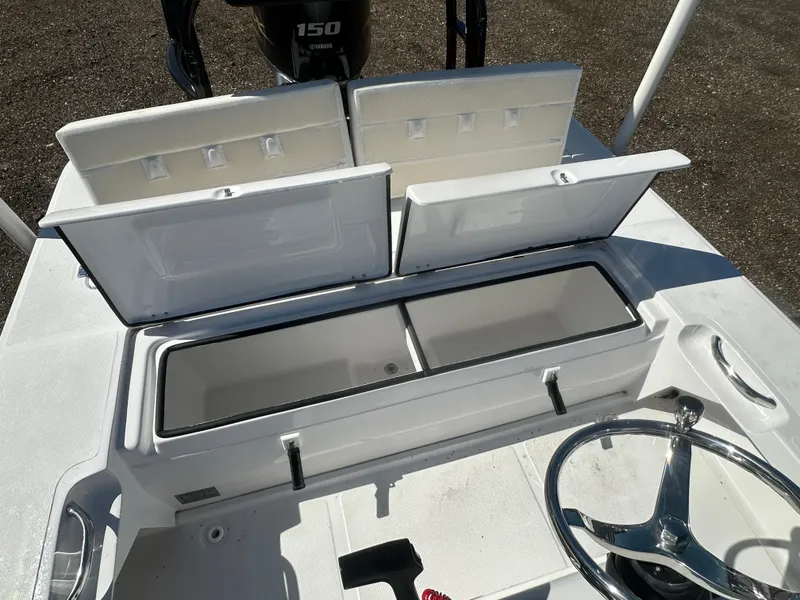 Slide: The Image of 2025 Action Craft 17 Flats Flyfisher boat interior with open storage compartments and steering wheel. - 16