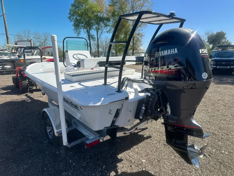 Slide: The Image of 2025 Action Craft 17 Flats Flyfisher boat with Yamaha 150 engine, parked outdoors. - 8