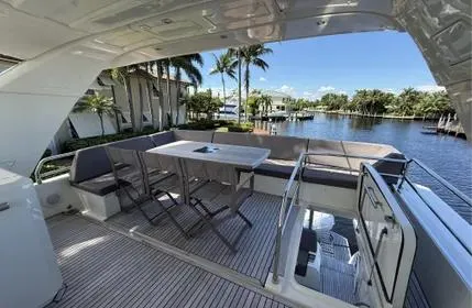 Slide: The Image of Luxurious 2018 Prestige 680 yacht deck with seating, table, and waterfront view. - 12