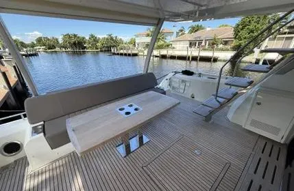 Slide: The Image of Luxury 2018 Prestige 680 yacht deck with seating and table, overlooking serene waterfront. - 21