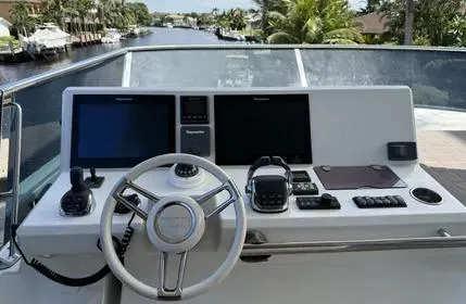 Slide: The Image of Control panel of a 2018 Prestige 680 yacht with navigation screens and steering wheel. - 8