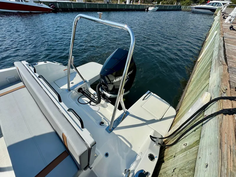 Slide: The Image of 2024 Beneteau Flyer 8 SUNdeck moored by a wooden dock, featuring a Mercury outboard motor. - 15