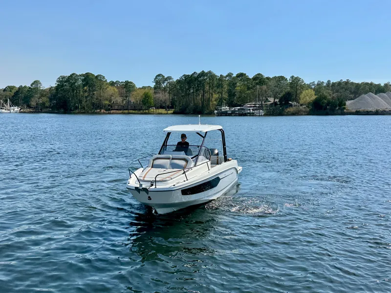 Slide: The Image of 2024 Beneteau Flyer 8 SUNdeck cruising on a serene lake with lush green shoreline. - 3