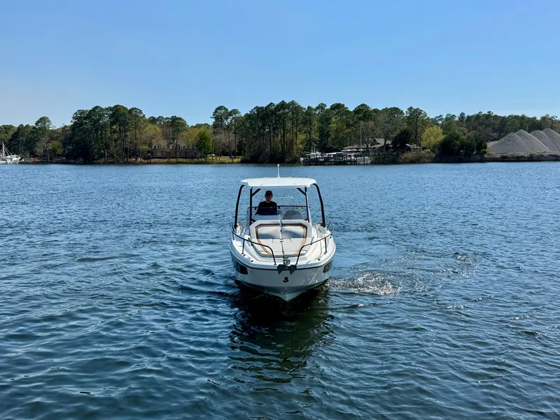 Slide: The Image of 2024 Beneteau Flyer 8 SUNdeck cruising on a serene lake with forested shoreline. - 4