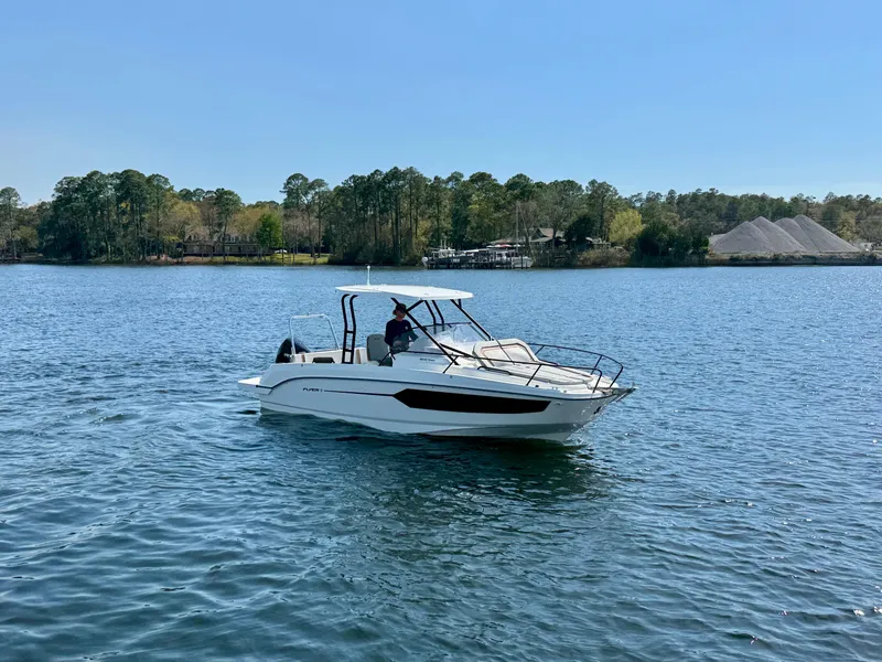 Slide: The Image of 2024 Beneteau Flyer 8 SUNdeck cruising on a serene lake under a clear blue sky. - 5