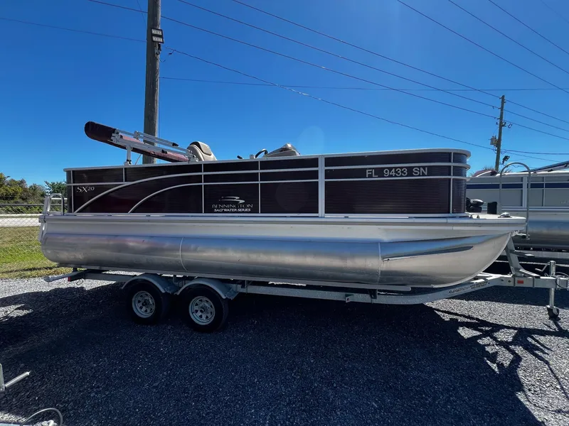Slide: The Image of 2019 Bennington SX20 SFX pontoon boat on trailer, parked outdoors. - 1
