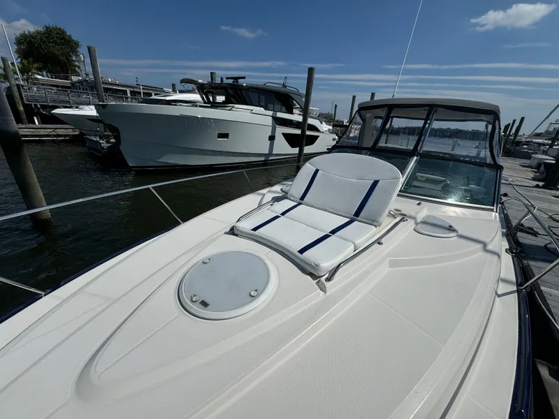 Slide: The Image of 2014 Monterey 340 Sport Yacht docked, featuring sleek design and sunbathing area. - 7