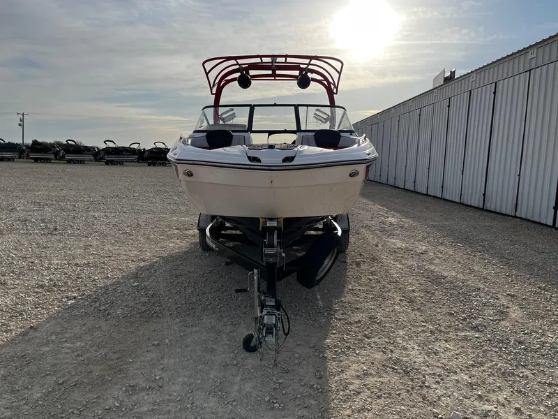 Slide: The Image of 2018 Yamaha Boats 242X E-Series on trailer, parked outdoors under a bright sky. - 2