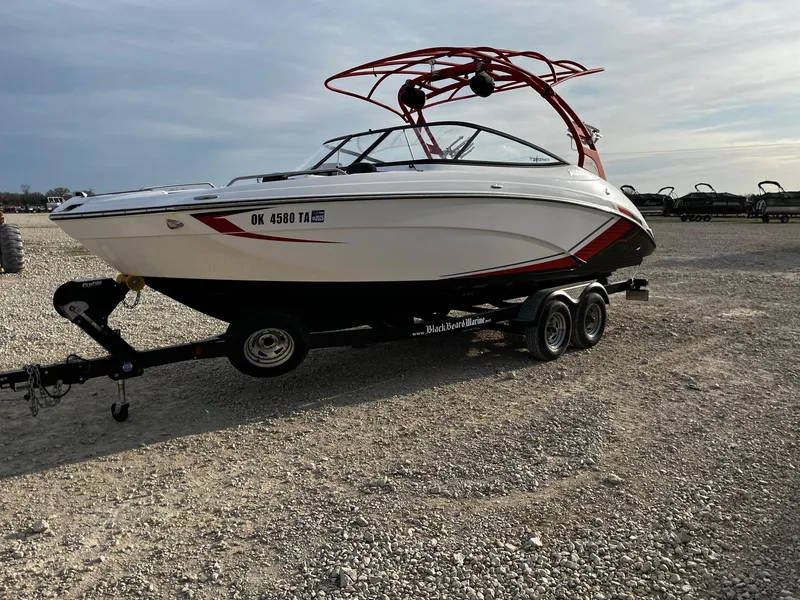 Slide: The Image of 2018 Yamaha Boats 242X E-Series on trailer, parked on gravel lot. - 3