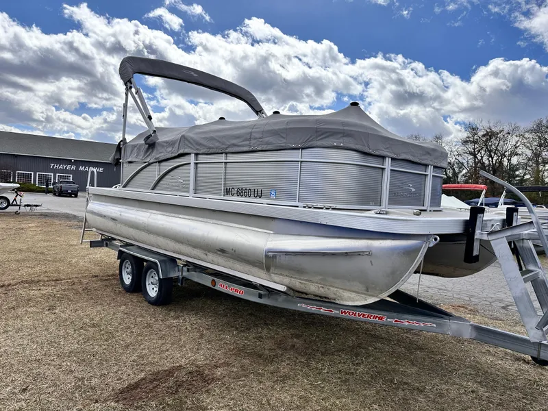 Slide: The Image of 2019 Bennington 20 SLM Pontoon on trailer, parked outdoors under cloudy sky. - 1