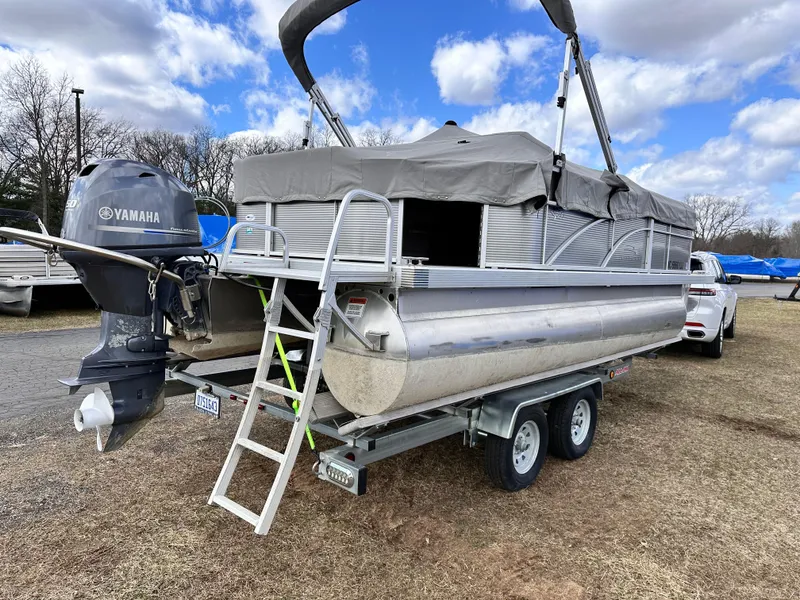 Slide: The Image of 2019 Bennington 20 SLM Pontoon with Yamaha engine on trailer, parked outdoors. - 2