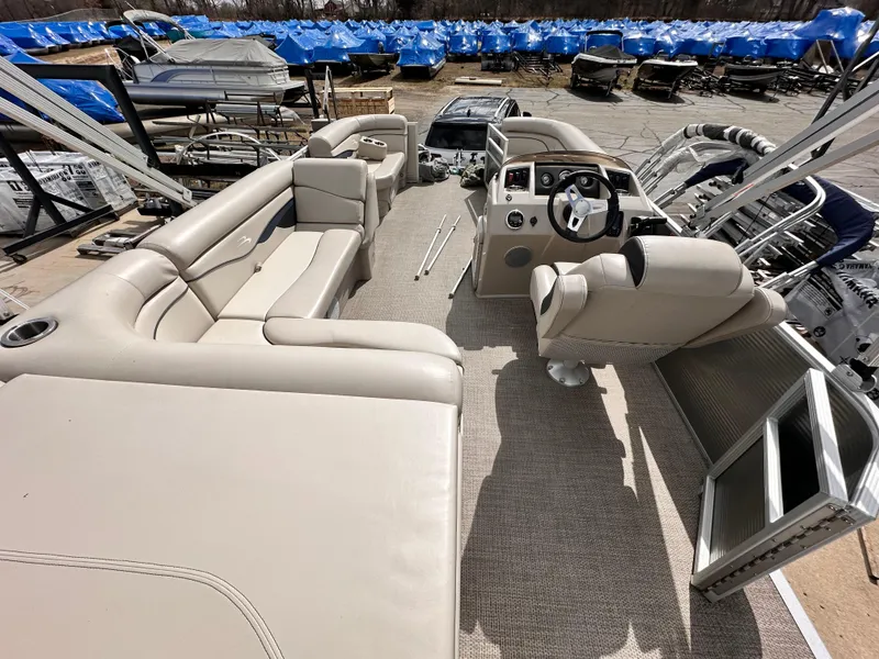 Slide: The Image of 2019 Bennington 20 SLM Pontoon boat interior with beige seating and steering console. - 5