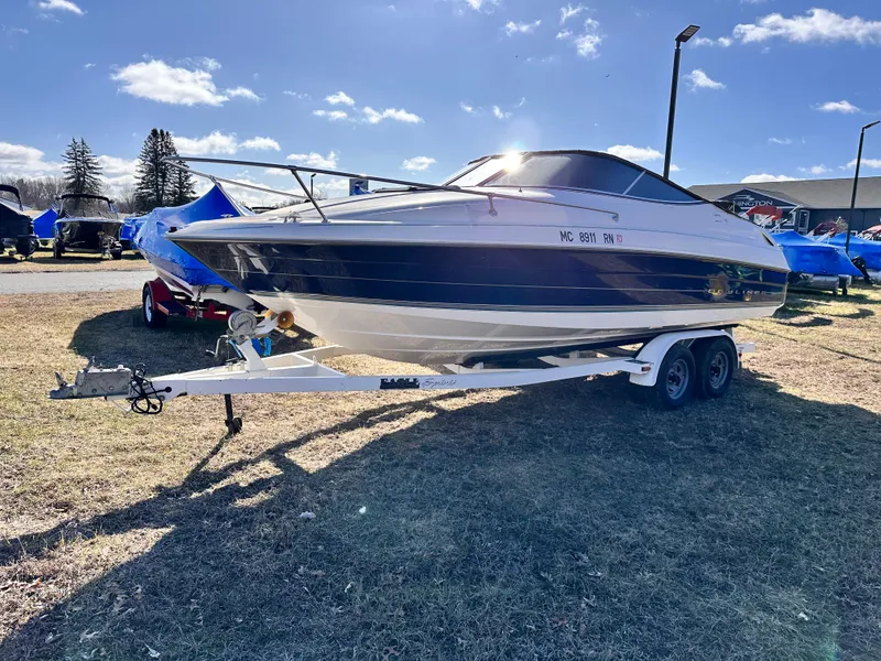 Slide: The Image of 1997 Bayliner 2352LS Cuddy boat on trailer under clear sky. - 1