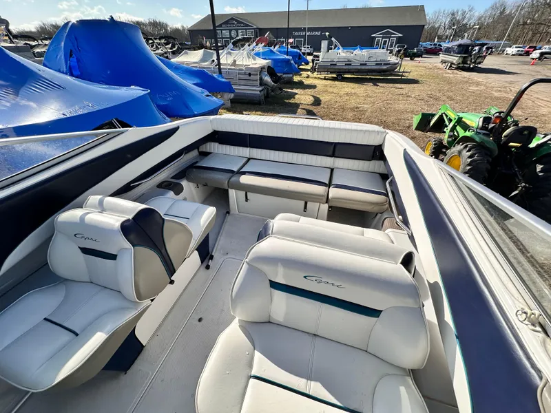 Slide: The Image of 1997 Bayliner 2352LS Cuddy boat interior with white seating and outdoor marina view. - 2