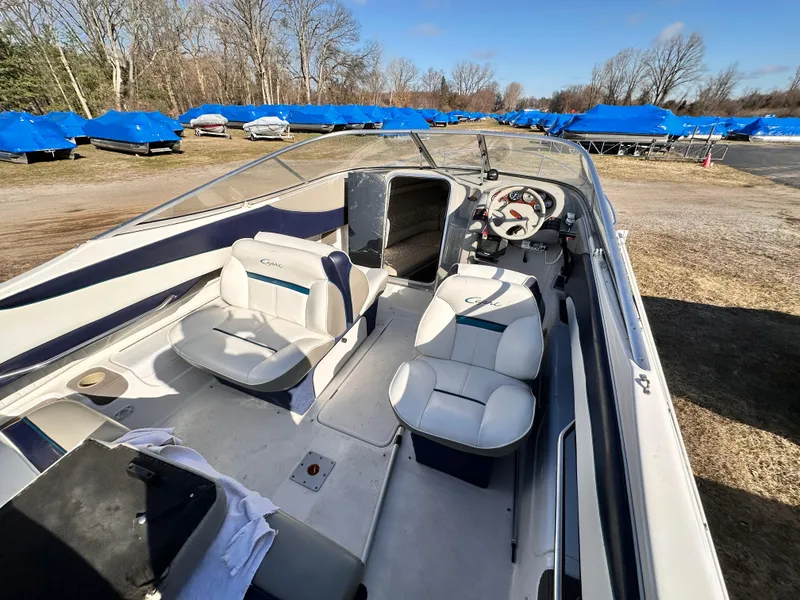 Slide: The Image of 1997 Bayliner 2352LS Cuddy boat interior with seating and steering wheel, parked outdoors. - 3