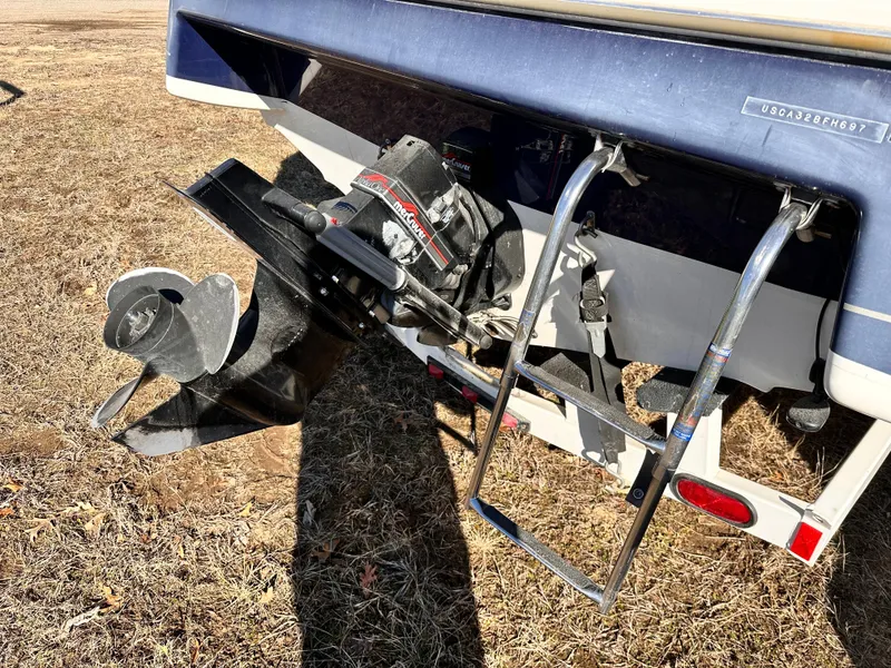 Slide: The Image of 1997 Bayliner 2352LS Cuddy boat stern with propeller and ladder on dry grass. - 4