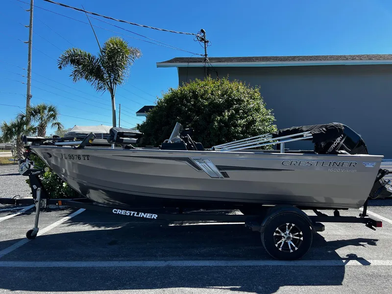 Slide: The Image of 2023 Crestliner 1600 Vision boat on trailer, parked outdoors near palm trees. - 1