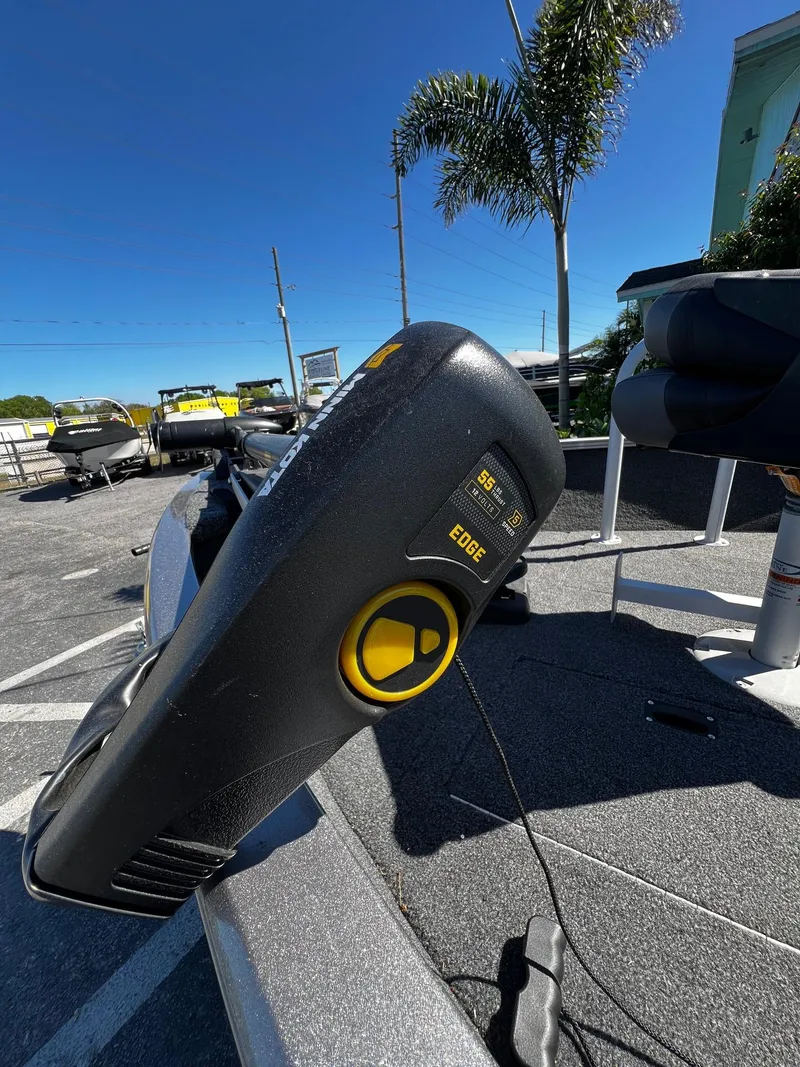 Slide: The Image of 2023 Crestliner 1600 Vision boat with trolling motor, parked outdoors under clear blue sky. - 7