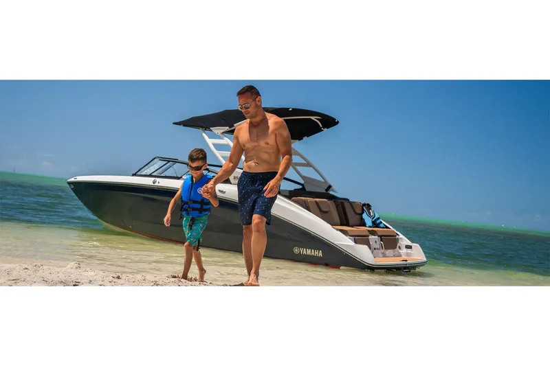 Slide: The Image of 2025 Yamaha Boats 252SE on beach with two people enjoying sunny day. - 11