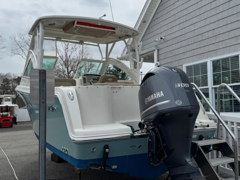 Slide: The Image of 2019 Sailfish 245 DC boat with Yamaha 300 engine, docked near a building. - 1
