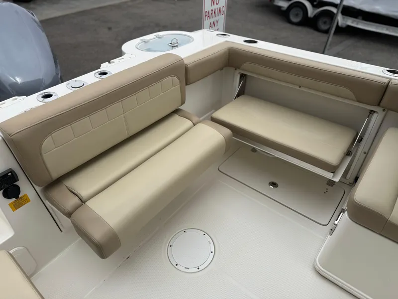 Slide: The Image of 2019 Sailfish 245 DC boat interior with beige seating and storage compartments. - 10