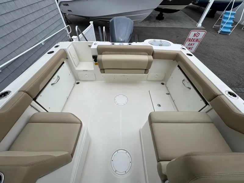 Slide: The Image of 2019 Sailfish 245 DC boat interior with beige seating and storage compartments. - 11