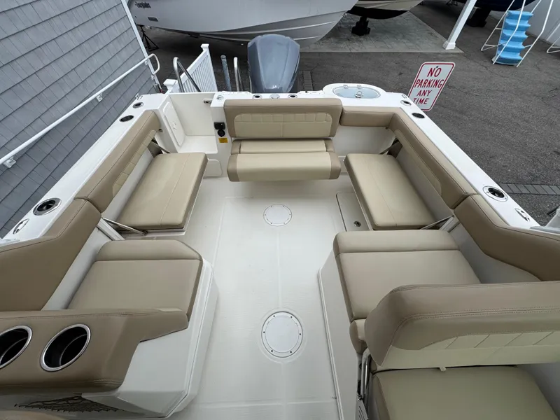 Slide: The Image of 2019 Sailfish 245 DC boat interior with beige seating and cup holders. - 12