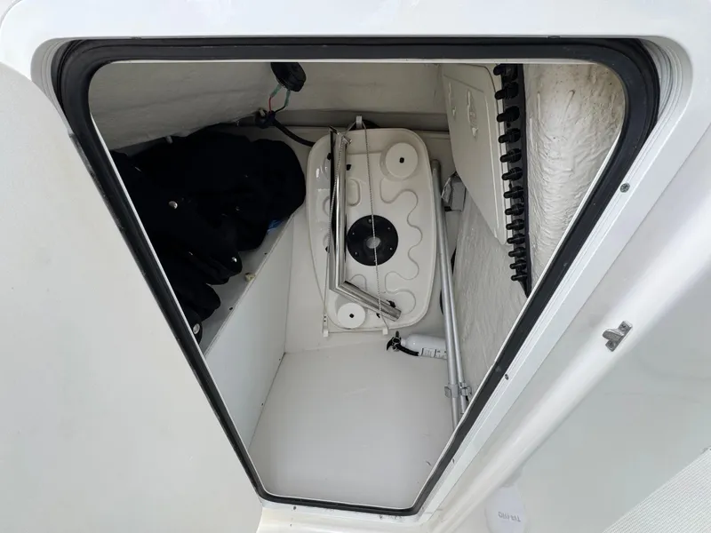 Slide: The Image of 2019 Sailfish 245 DC storage compartment with organized equipment and gear. - 13