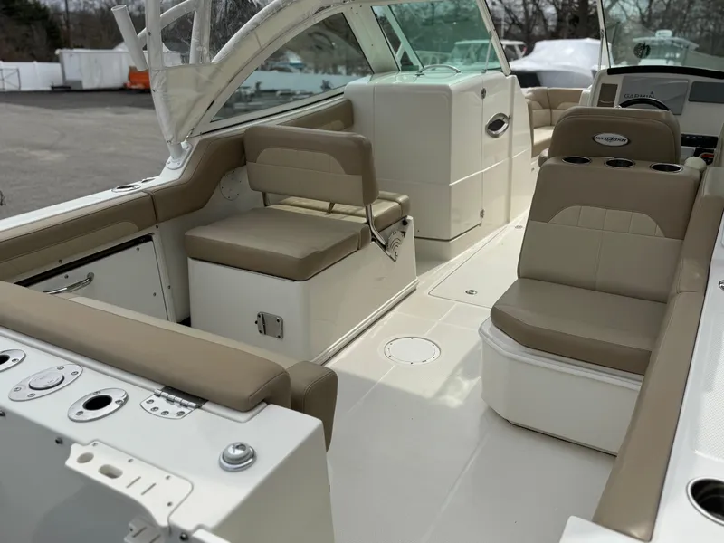 Slide: The Image of 2019 Sailfish 245 DC boat interior with beige seating and modern controls. - 2