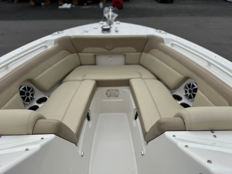 Slide: The Image of 2019 Sailfish 245 DC boat interior with beige cushioned seating and built-in speakers. - 3