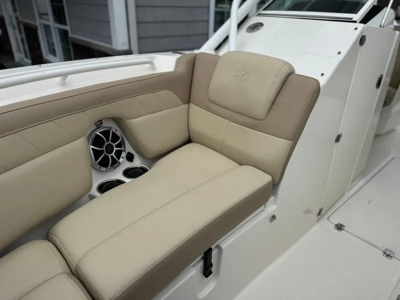 Slide: The Image of 2019 Sailfish 245 DC boat interior with beige seating and speaker system. - 4