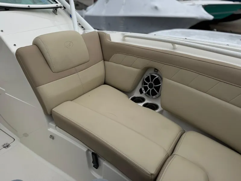 Slide: The Image of 2019 Sailfish 245 DC boat interior with beige seating and built-in cup holders. - 5