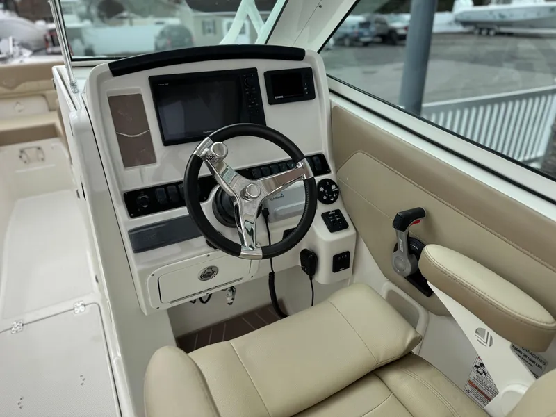 Slide: The Image of 2019 Sailfish 245 DC boat cockpit with steering wheel and control panel. - 6