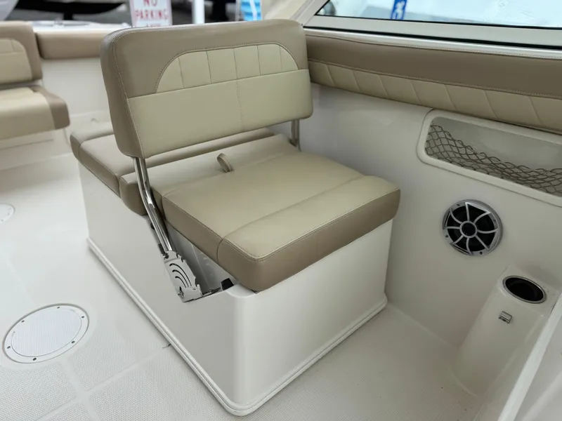 Slide: The Image of 2019 Sailfish 245 DC boat interior with beige seating and speaker. - 7
