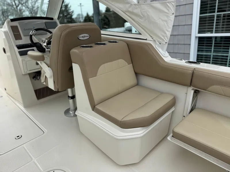 Slide: The Image of 2019 Sailfish 245 DC boat interior with beige seating and steering console. - 9
